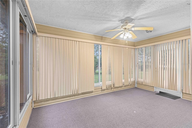 unfurnished room with a textured ceiling, ceiling fan, and carpet floors