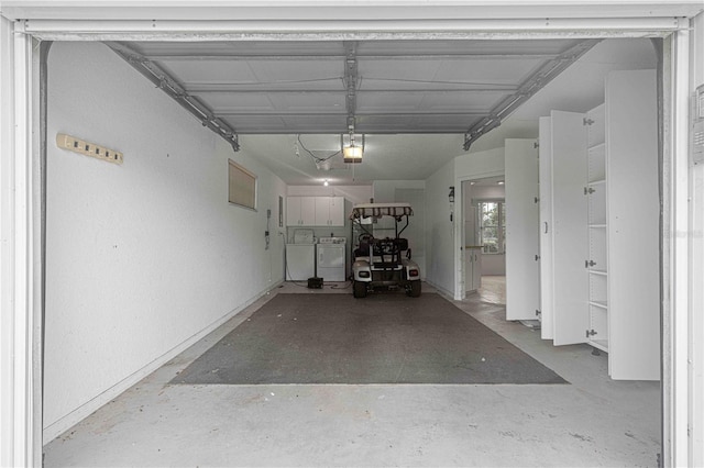 garage with a garage door opener and washing machine and dryer