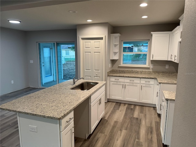 kitchen featuring white cabinetry, dark hardwood / wood-style flooring, sink, and an island with sink