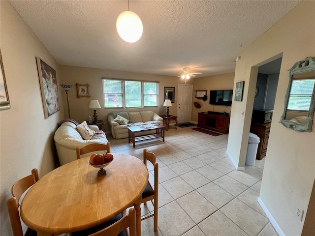 tiled living room with ceiling fan and a textured ceiling