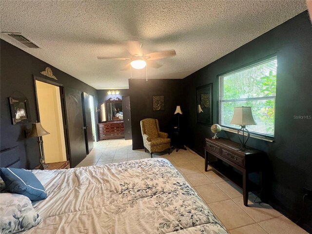 bedroom featuring ceiling fan, a textured ceiling, and light tile patterned floors