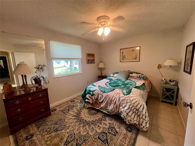 tiled bedroom featuring ceiling fan and a textured ceiling