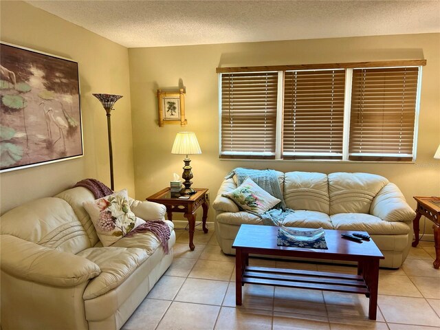 living room with a textured ceiling and light tile patterned floors