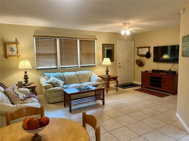 tiled living room featuring ceiling fan and a textured ceiling