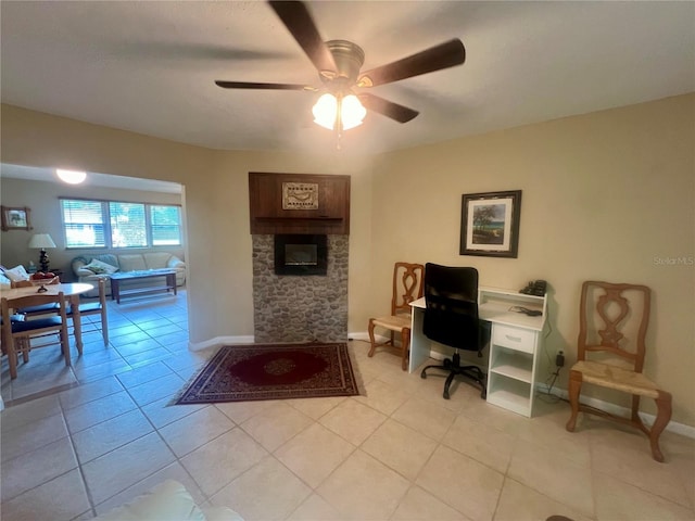 tiled office with ceiling fan and a fireplace