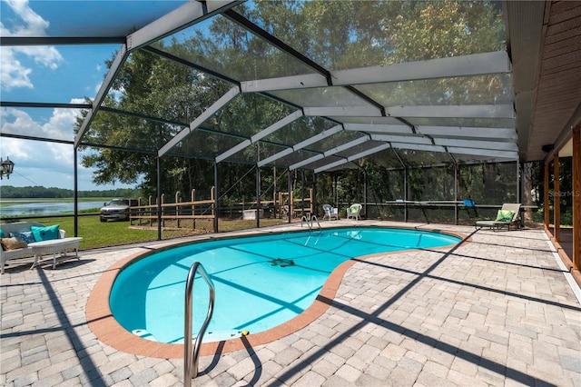 view of swimming pool featuring a patio, glass enclosure, and a water view