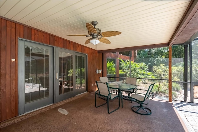 unfurnished sunroom featuring ceiling fan