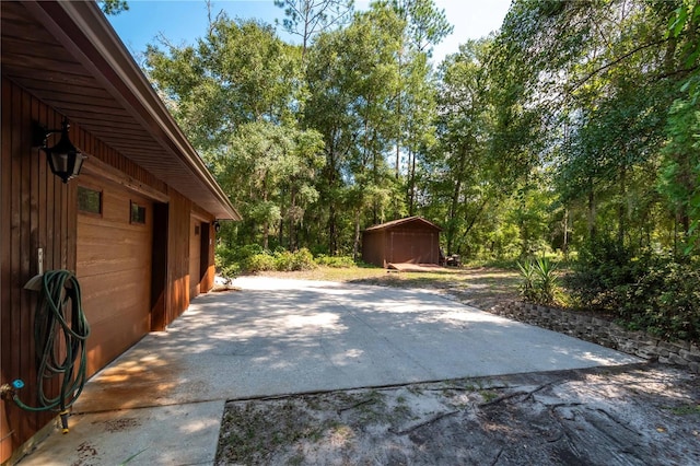 view of patio / terrace with a garage and an outbuilding