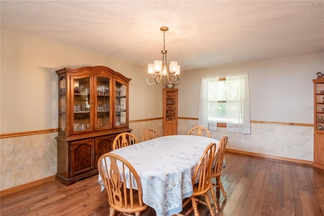 dining room featuring a chandelier, a textured ceiling, and hardwood / wood-style flooring