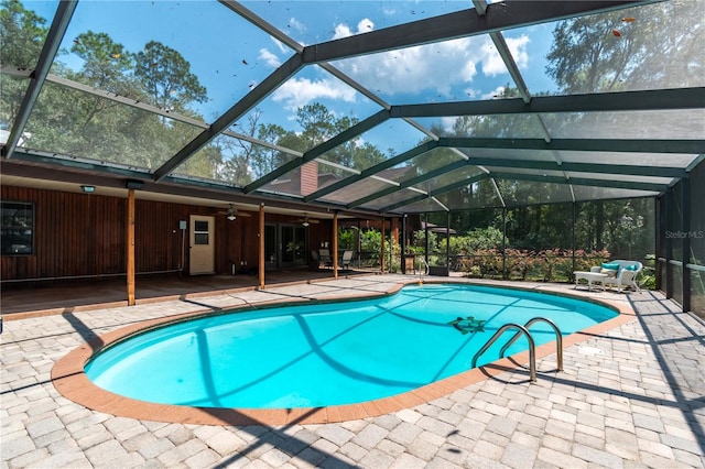 view of swimming pool featuring glass enclosure and a patio