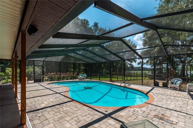 view of swimming pool with glass enclosure and a patio area