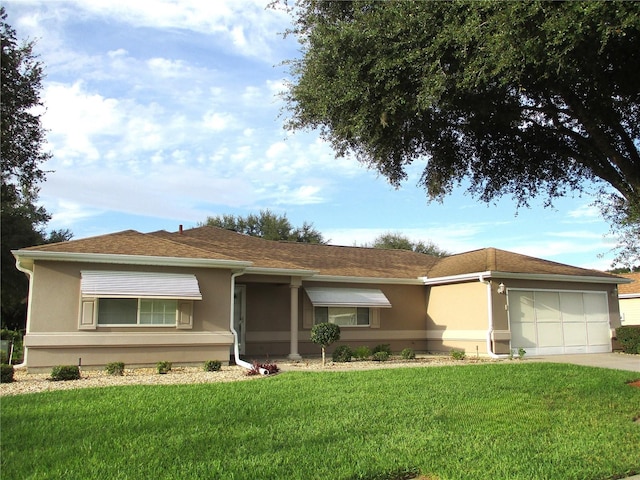 single story home with a garage and a front lawn