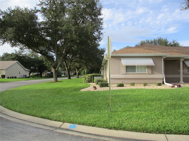 view of side of home with a yard