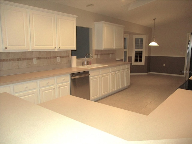 kitchen featuring white cabinetry, hanging light fixtures, stainless steel dishwasher, and sink