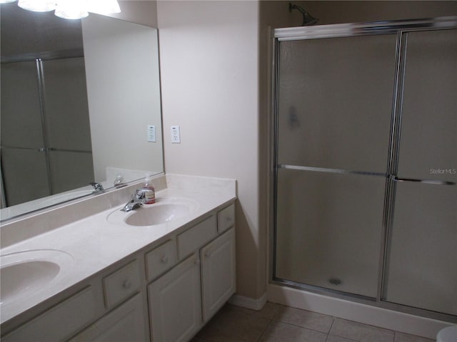 bathroom with tile patterned flooring, vanity, and walk in shower