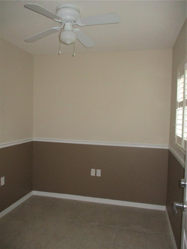 tiled spare room featuring ceiling fan