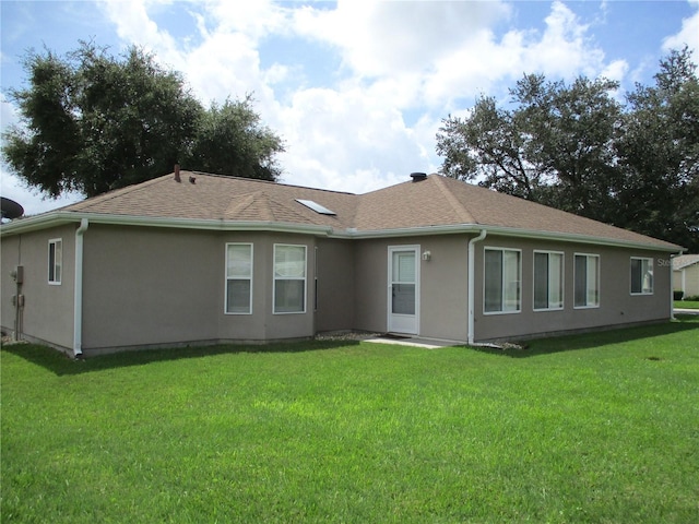 rear view of property with a yard