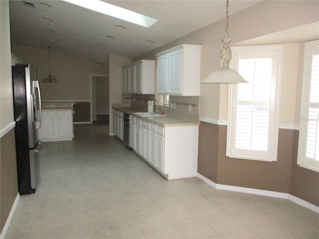 kitchen with white cabinets, a healthy amount of sunlight, black dishwasher, and stainless steel fridge