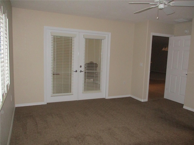 empty room with french doors, ceiling fan, and dark colored carpet