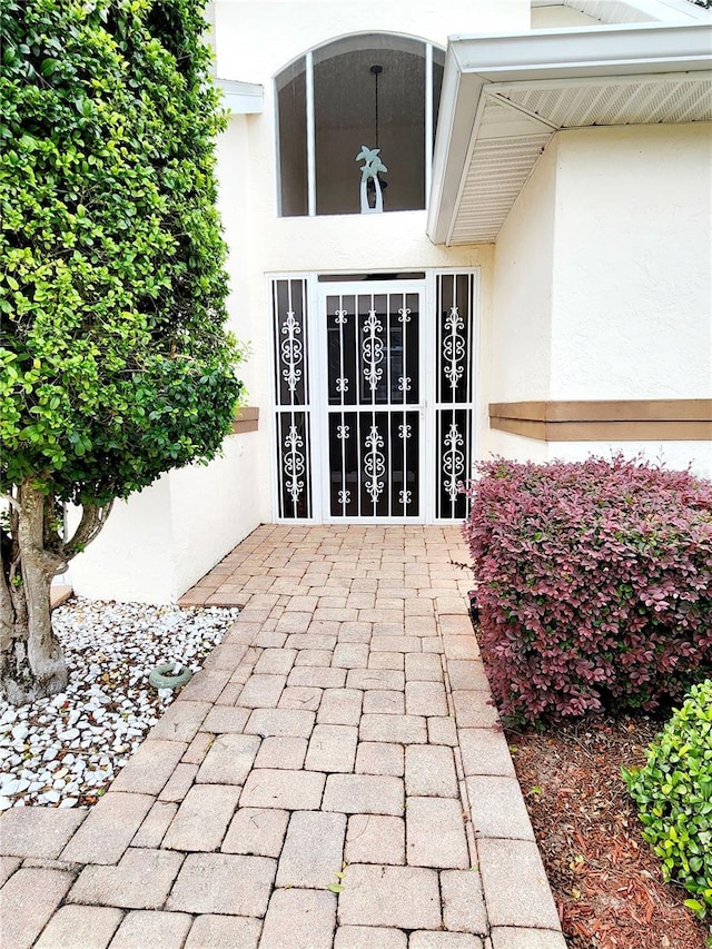 doorway to property featuring stucco siding