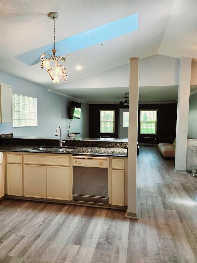 kitchen with plenty of natural light, light hardwood / wood-style flooring, stainless steel dishwasher, and vaulted ceiling with skylight