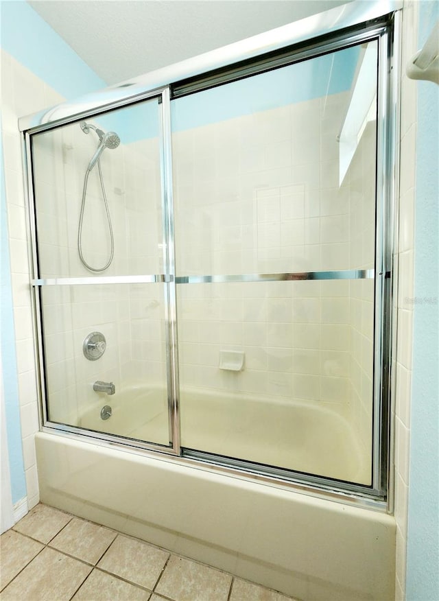 full bath with enclosed tub / shower combo and tile patterned floors