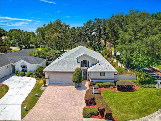 17808 SE 115th Ct, Summerfield, FL 34491 - view of front of home featuring driveway, a garage, a front lawn, stucco siding, and roof with shingles