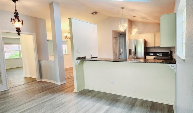 17808 SE 115th Ct, Summerfield, FL 34491 - kitchen with stainless steel fridge with ice dispenser, a chandelier, wood finished floors, dark stone counters, and lofted ceiling