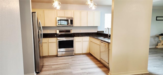 17808 SE 115th Ct, Summerfield, FL 34491 - kitchen with appliances with stainless steel finishes, a sink, a chandelier, light wood finished floors, and dark countertops