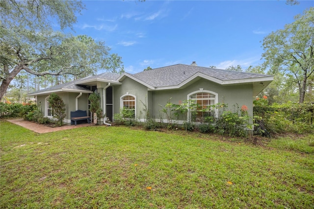 ranch-style house featuring a front lawn and a patio