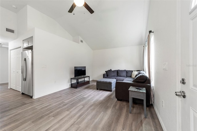 living room with lofted ceiling, a healthy amount of sunlight, ceiling fan, and light hardwood / wood-style flooring