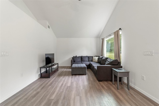 living room featuring lofted ceiling and light hardwood / wood-style flooring