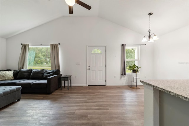 living room featuring ceiling fan with notable chandelier, hardwood / wood-style flooring, lofted ceiling, and a wealth of natural light