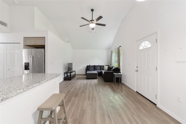 interior space with high vaulted ceiling, ceiling fan, and light hardwood / wood-style floors