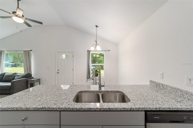 kitchen featuring dishwashing machine, light stone counters, sink, and lofted ceiling