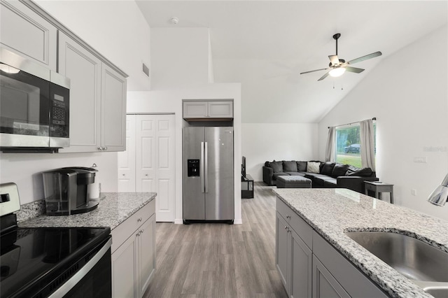 kitchen with gray cabinetry, appliances with stainless steel finishes, sink, ceiling fan, and light wood-type flooring