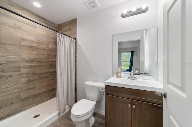 bathroom with vanity, toilet, wood-type flooring, and walk in shower