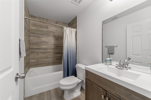 full bathroom featuring toilet, wood-type flooring, shower / tub combo, vanity, and a textured ceiling