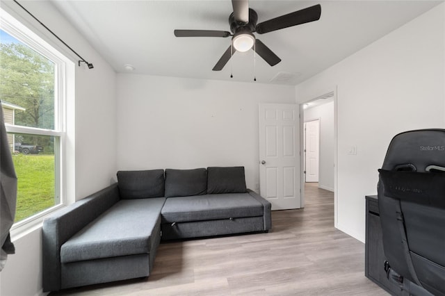 living room featuring light hardwood / wood-style flooring and ceiling fan