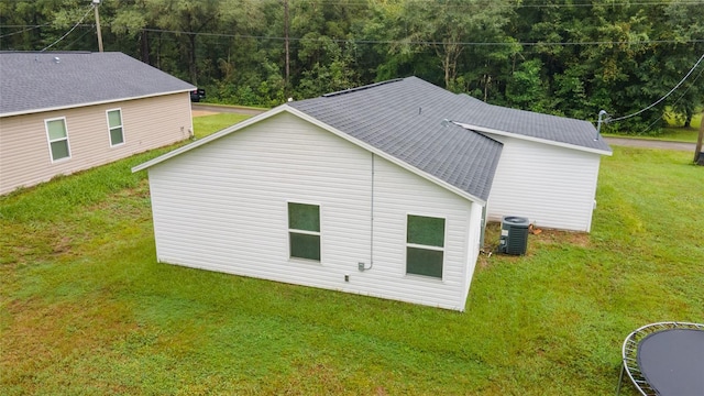 view of property exterior with a yard and central AC