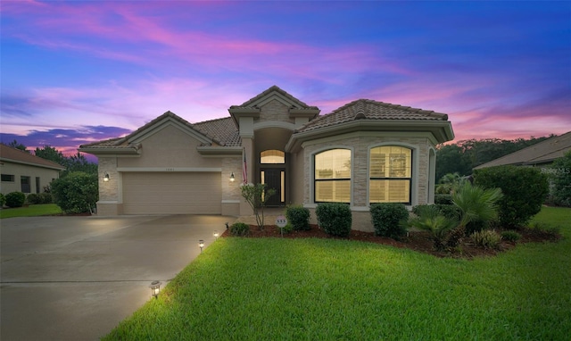 view of front of property with a yard and a garage