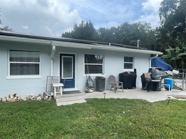 back of property featuring a yard and a patio area