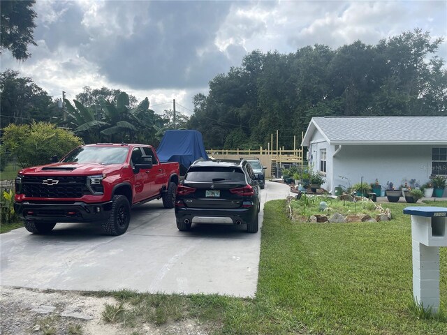 view of vehicle parking with a yard