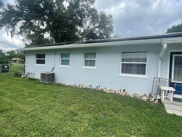 view of side of property featuring a yard and central air condition unit