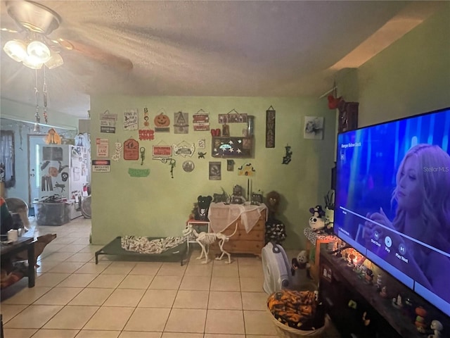 tiled living room with ceiling fan and a textured ceiling