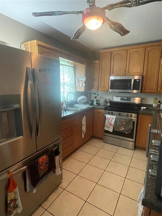 kitchen with decorative backsplash, appliances with stainless steel finishes, sink, and light tile patterned floors