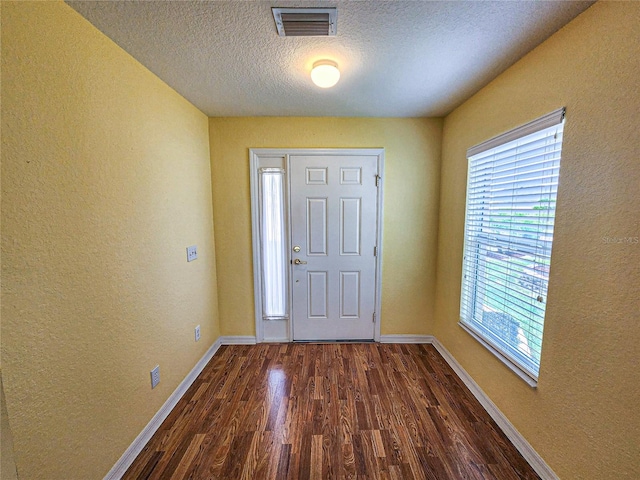 entrance foyer with a textured ceiling and dark wood-type flooring