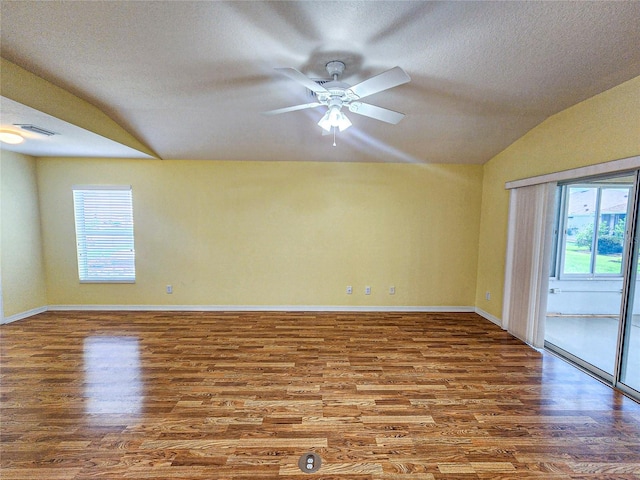 unfurnished room featuring vaulted ceiling, ceiling fan, hardwood / wood-style flooring, and a textured ceiling