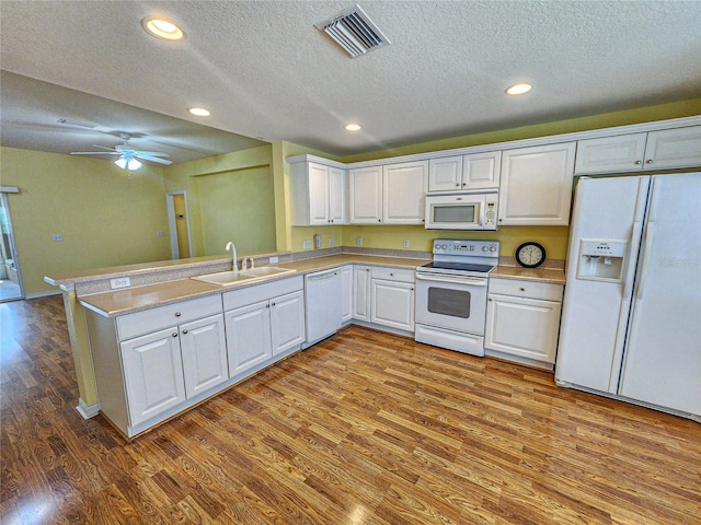 kitchen featuring sink, white cabinets, kitchen peninsula, white appliances, and ceiling fan