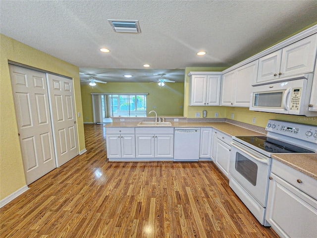 kitchen with light wood-type flooring, sink, white cabinets, white appliances, and ceiling fan